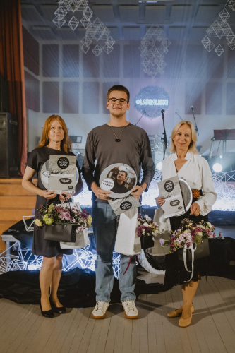 Elizabete latgaliskajā dzejis slamā “Rogovkys dzejis voga”, nu kreisuos: Elizabete, Linards Kalniņš (nu Dagdys) i Dace Tihovska, 2025. g.
